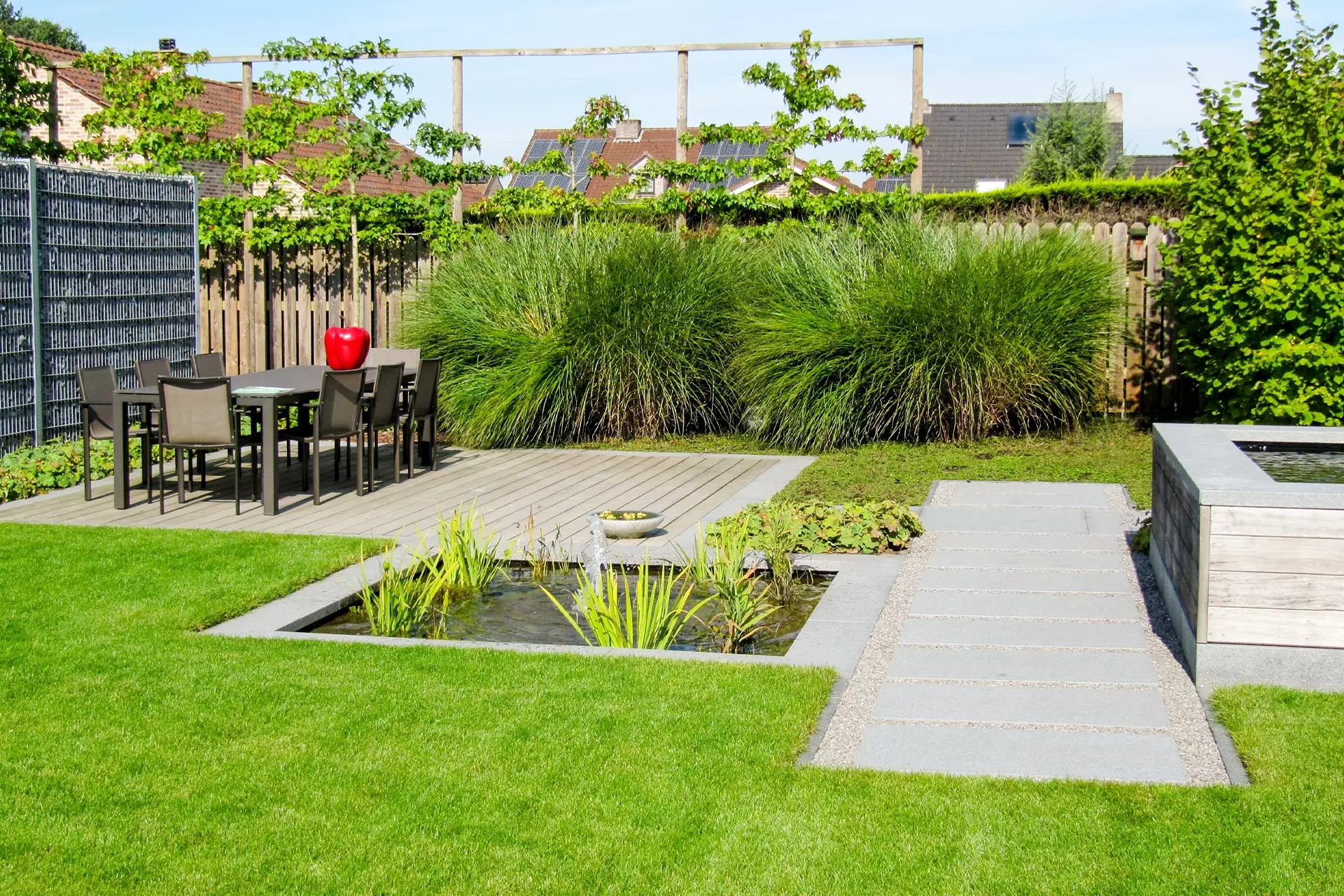 Modern tuinterras met siergrassen en verhardingen door Alle Tuinwerken Bart Janssen in Oudsbergen – foto 2